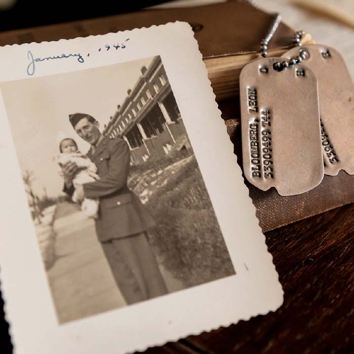 black and white photo of a soldier and infant sitting next to dog tags