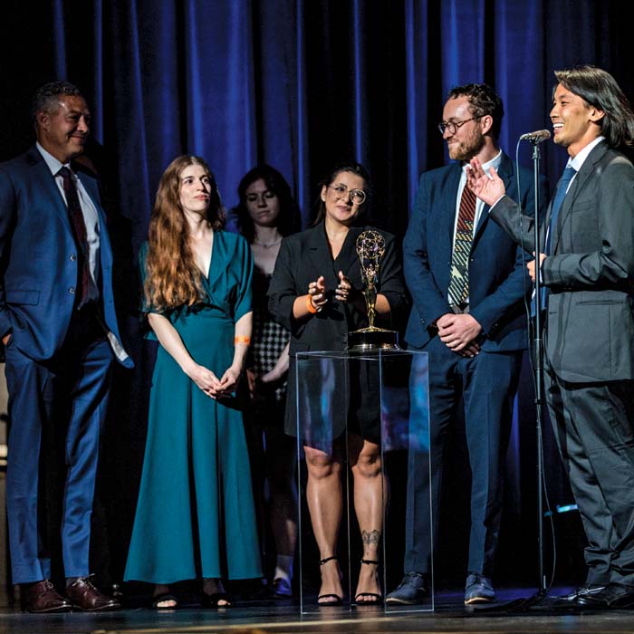 color photo of a group of people accepting an award onstage