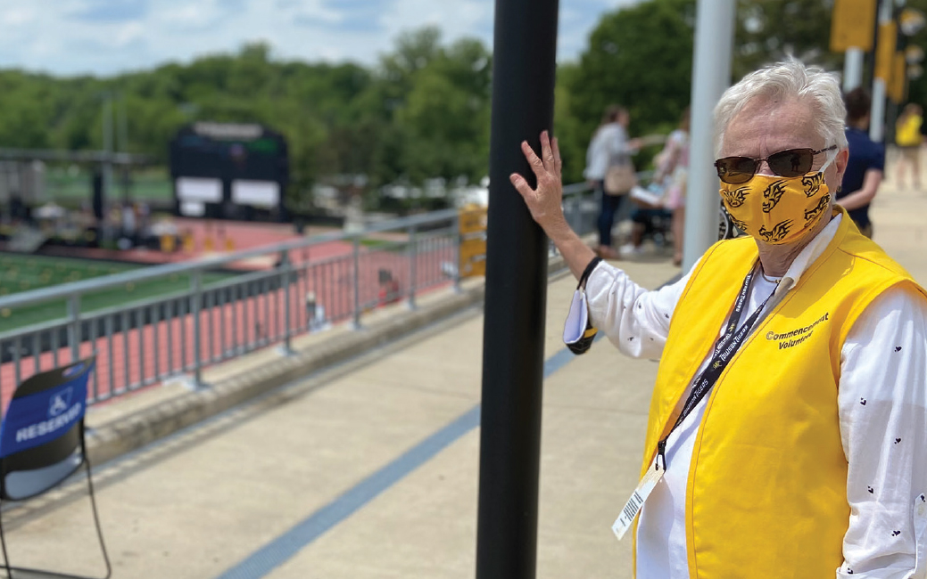 A masked volunteer at Commencement