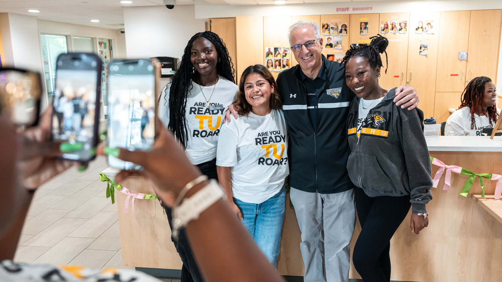 Towson University president Mark Ginsberg takes a photo with students during move-in