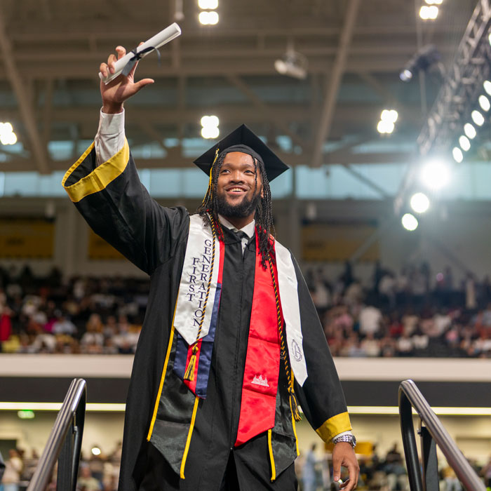 Student holding up diploma at Commencement