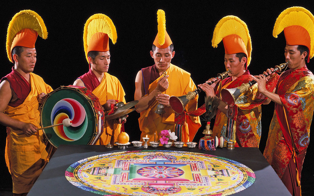 Tibetan Buddhist monks from the Drepung Loseling Monastery pray over a mandala sand painting. Photo courtesy of Mystical Arts of Tibet.