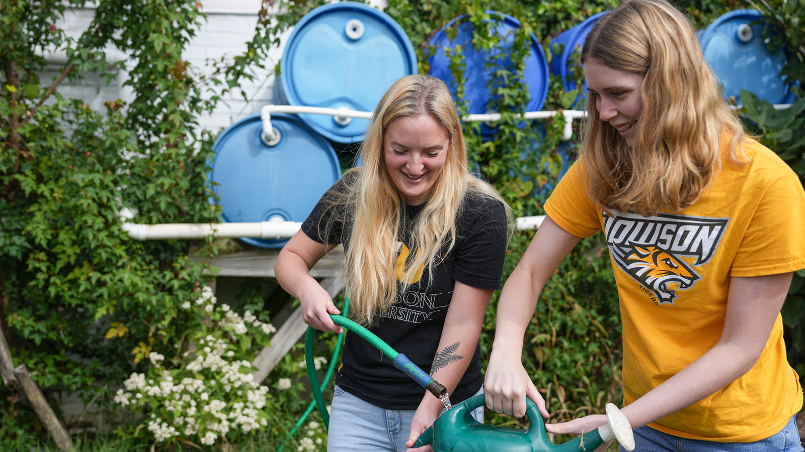 Two people in a garden filling a watering pot
