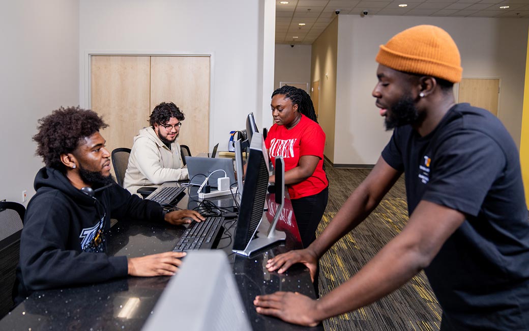 Students at tech help counter with computer monitors