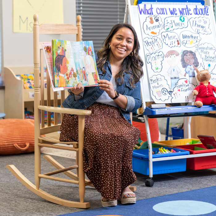 Teresa reads a children's book to her students
