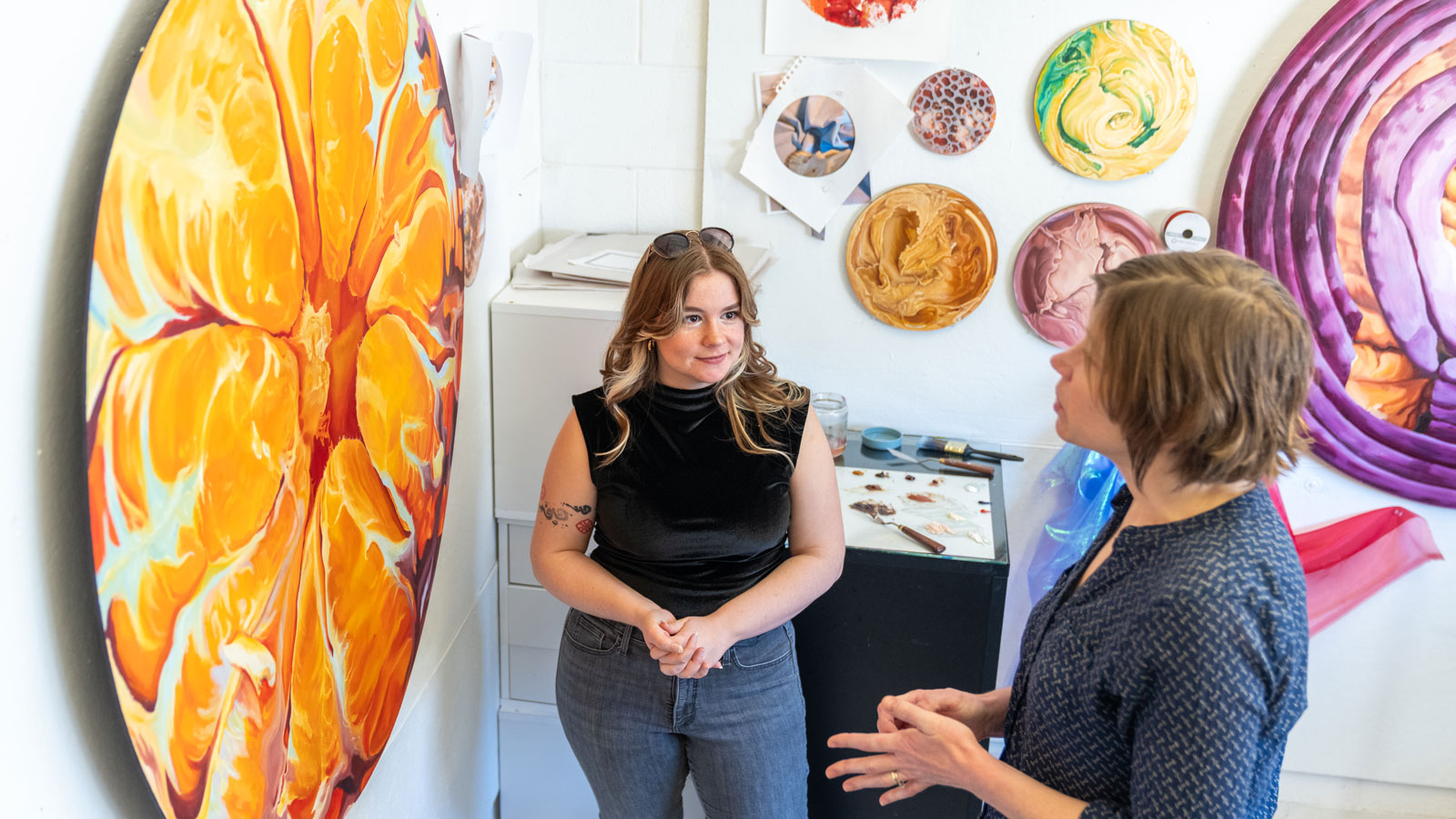 COFAC Fine Art master's student discusses artwork with faculty member