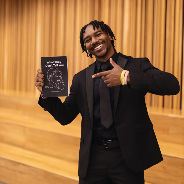 Alphonso holds his first published book of poetry