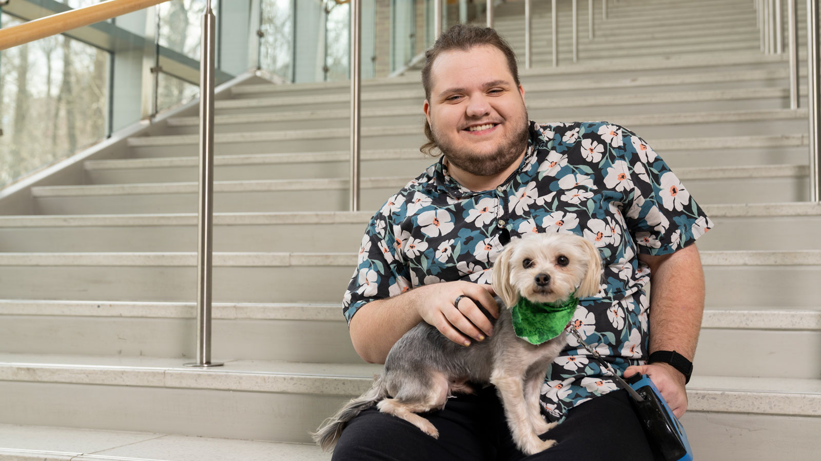 NeuroDiverse Peer Educator Andy Miller sits with his pup Prince