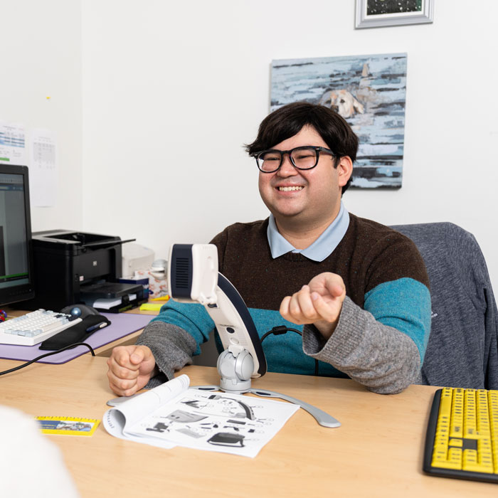 Student Joshua Ouyporn discusses assistive technology with a student in the Accessibility & Disability Services Office