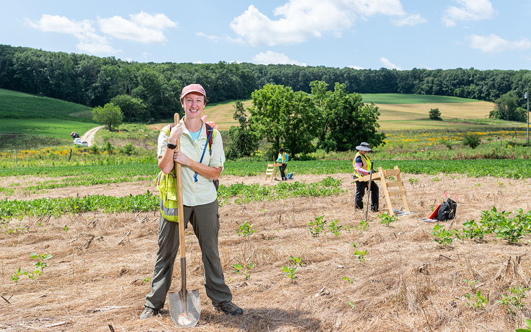 Woman in farm field holding shovel