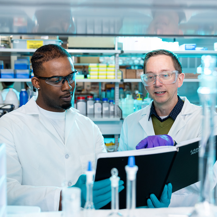 John Sivey (left) working with a student in his lab