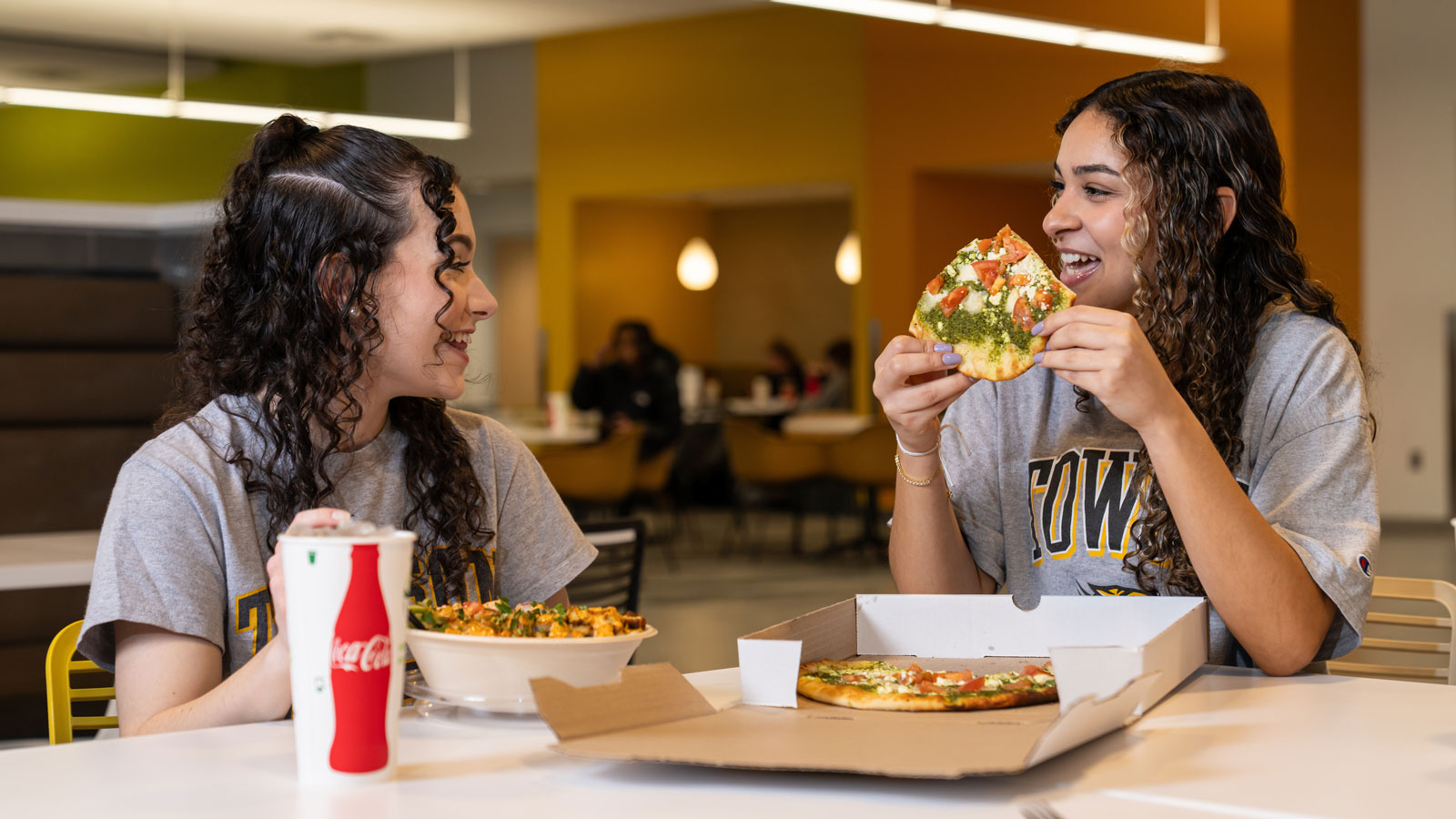 Students eating pizza at the University Union food market 