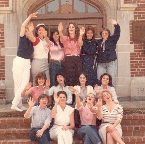 A group of Towson students waving from the front steps of Stephens Hall