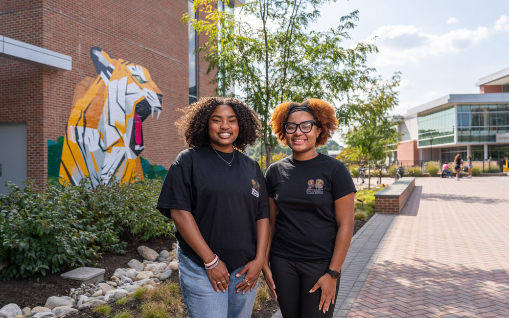 Student leaders stand outside of university union tiger mural
