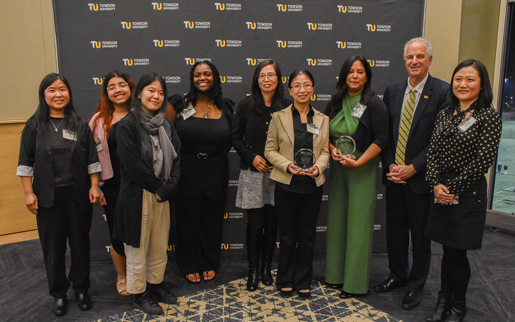 faculty and student awardees, holding awards, stand with president ginsberg at 2023 btu partnerships awards ceremony