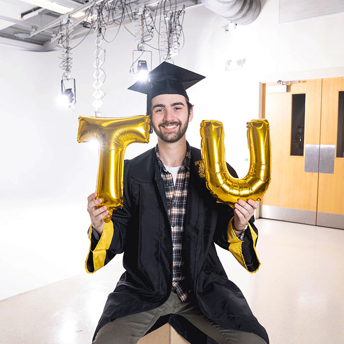 Student holding TU balloons