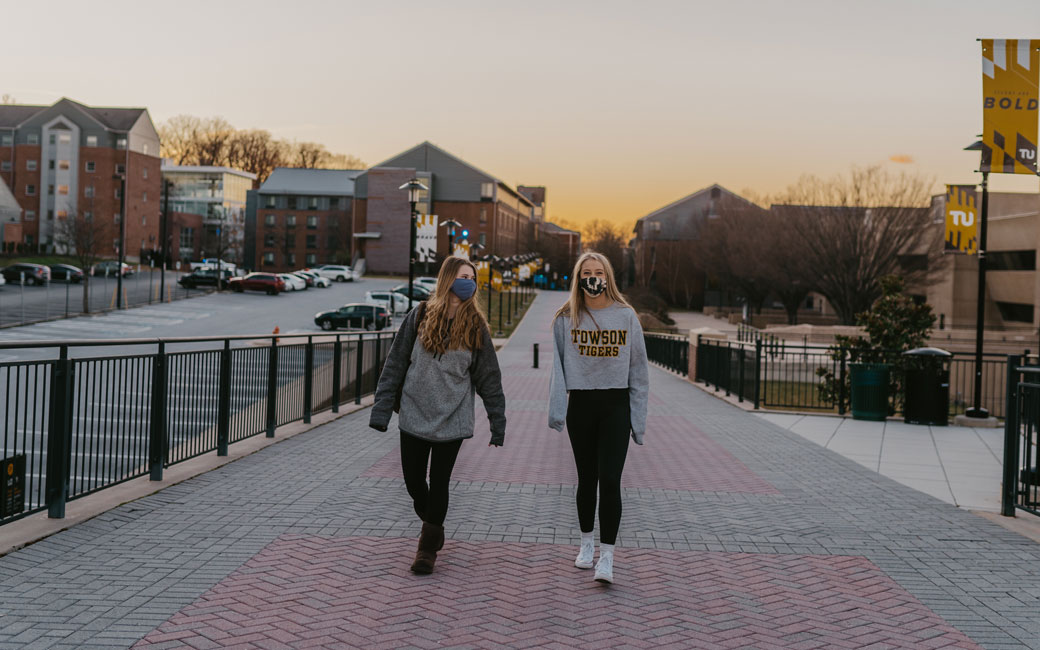 Students, in masks, walking on campus