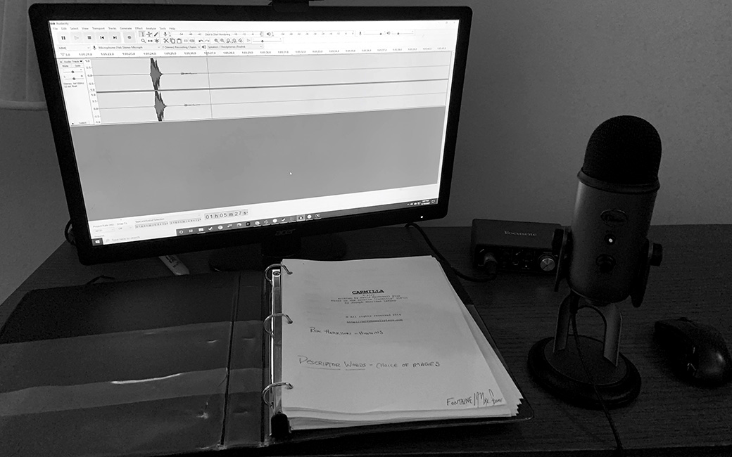 Black and white photo of computer with script binder and mic