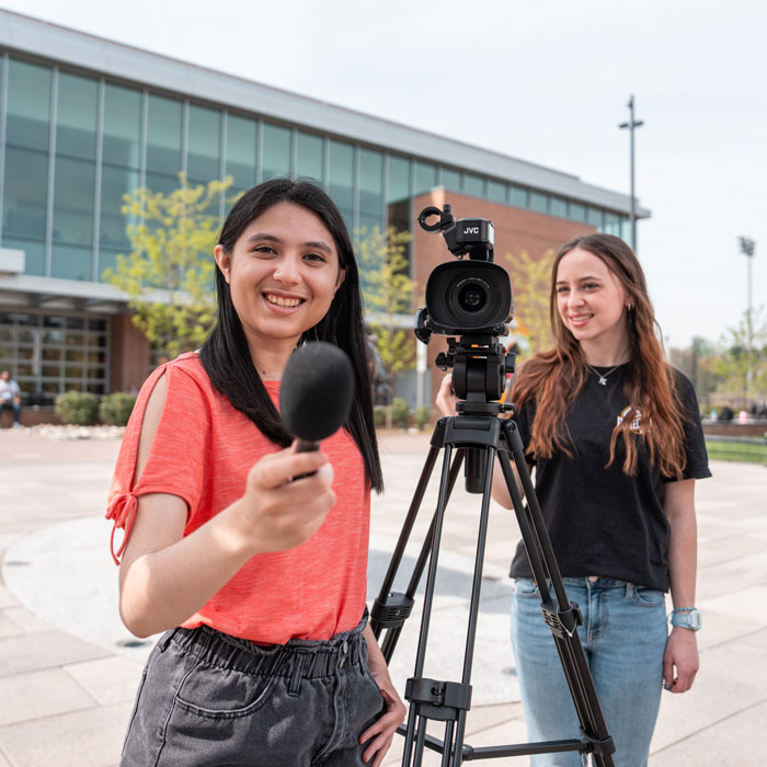 Students operate microphone and video camera outside of the University Union