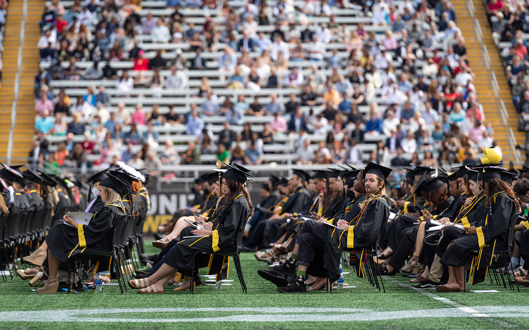 Students sitting in Johnny Unitas Stadium for Commencement