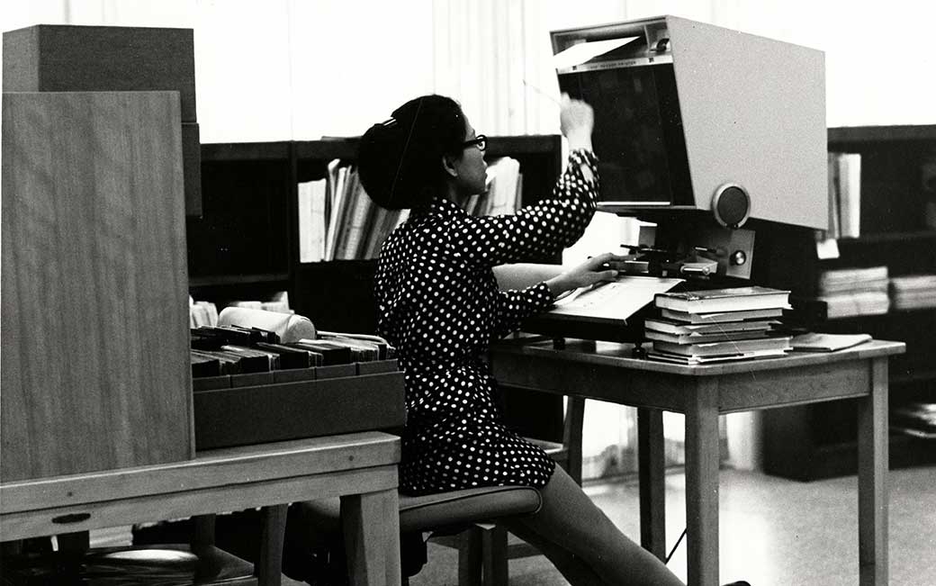 Cook Library staffer at a microfiche machine