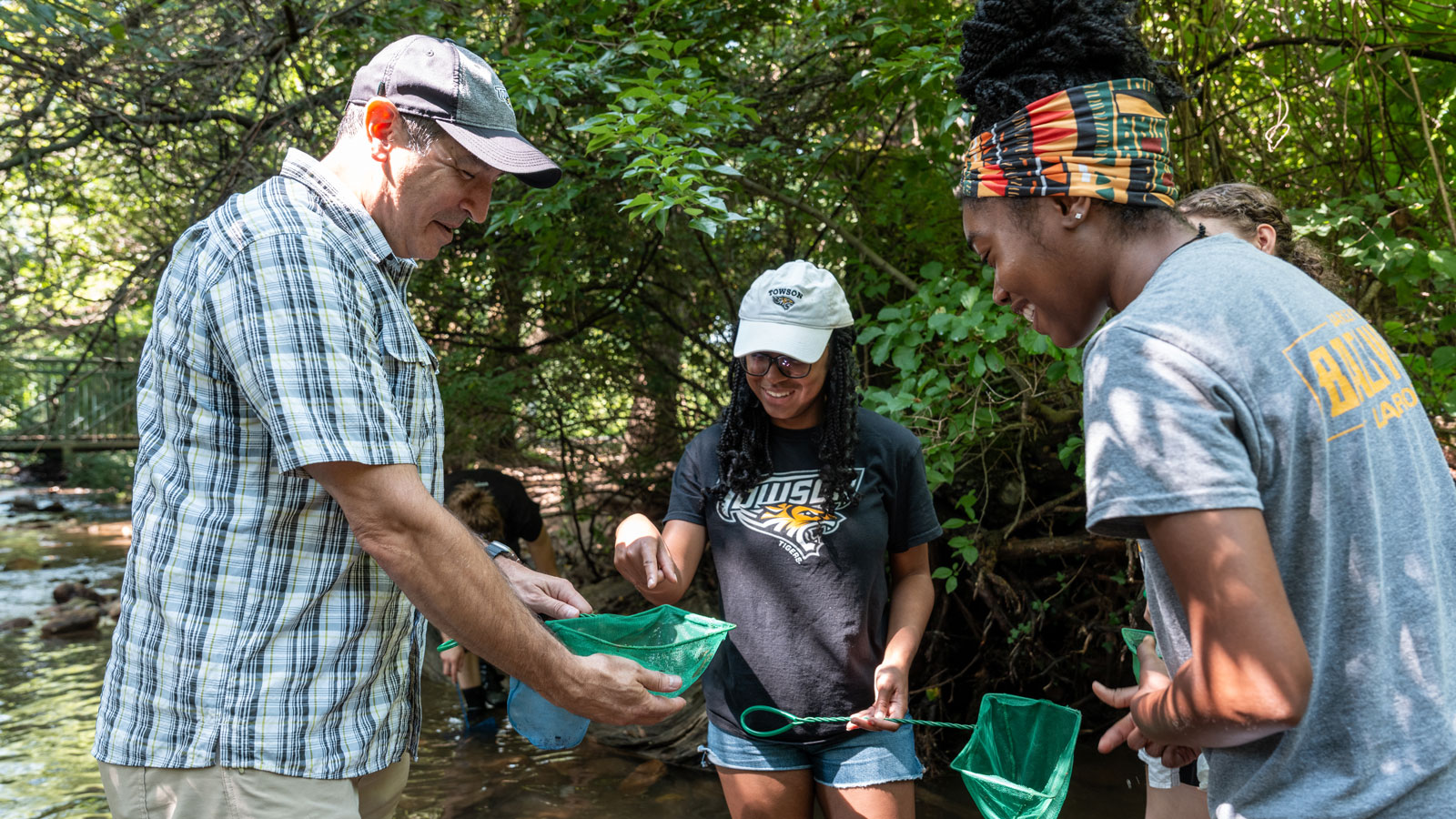 Dr. Christopher Salice shows his crayfish catch to students 