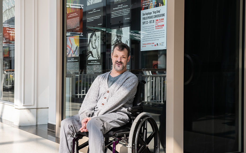Dan Keplinger in front of window display of his artwork