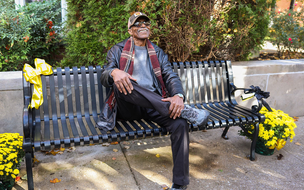 Dean Chapman sits on a bench, smiling