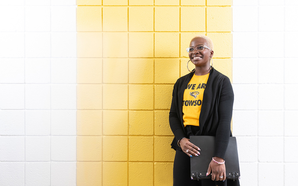 Woman standing against yellow and white wall