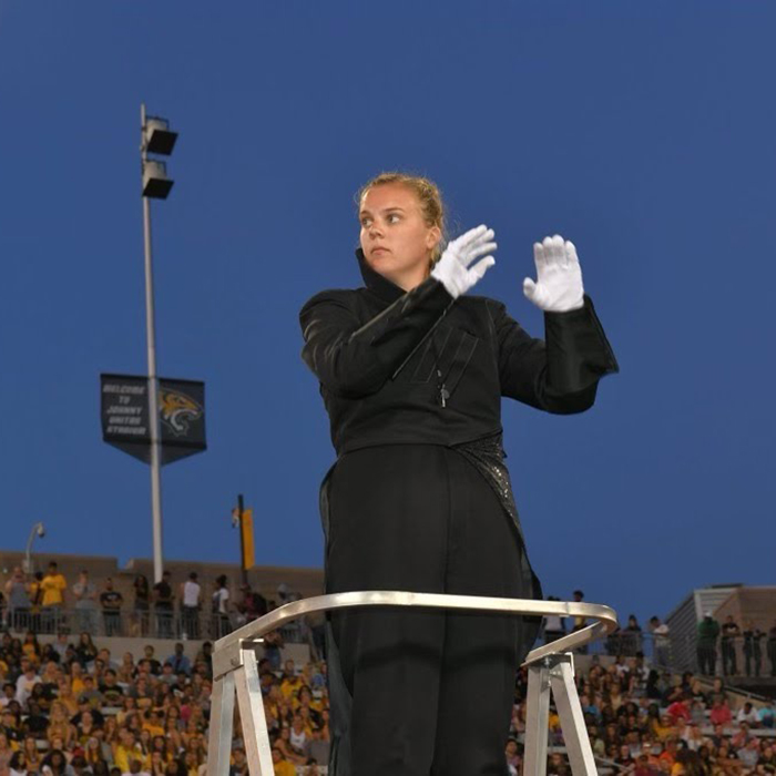 Student drum major conducts during game