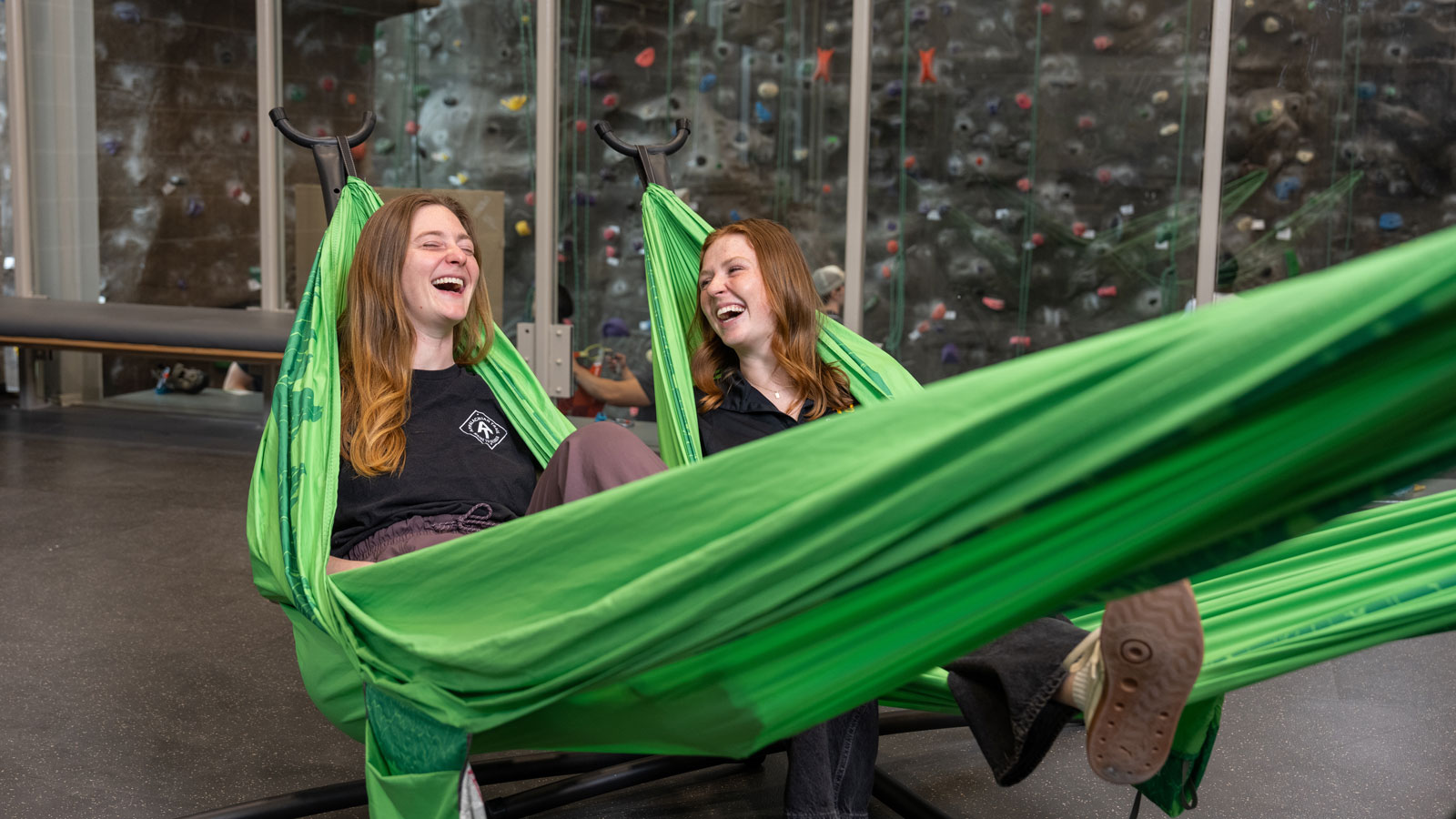 Zoe Huff, assistant director of outdoor adventures in TU’s Campus Recreation Office, and student Kennedy Krohn sit together in hammocks