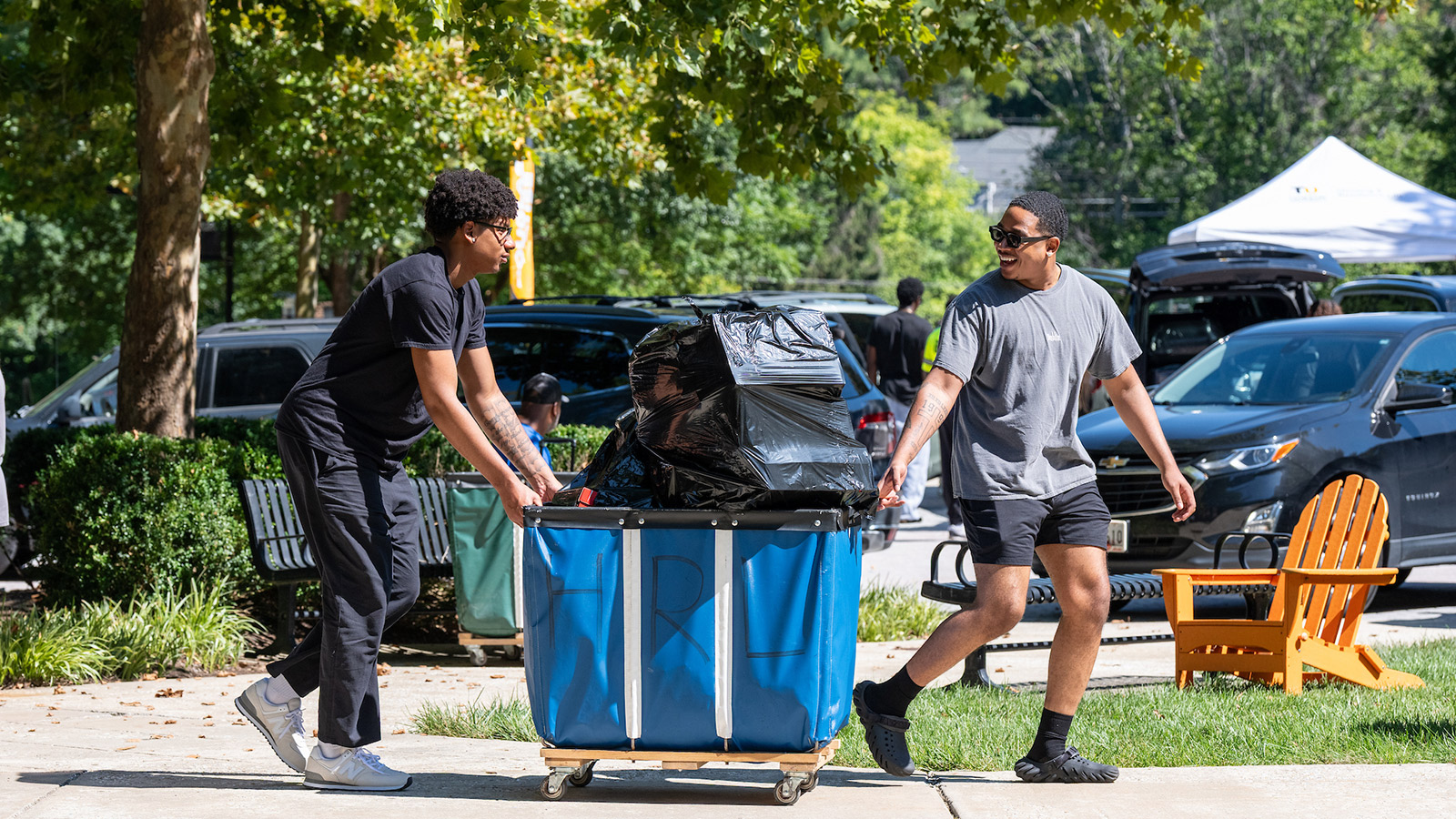 students pushing a cart filled with items during campus move-in