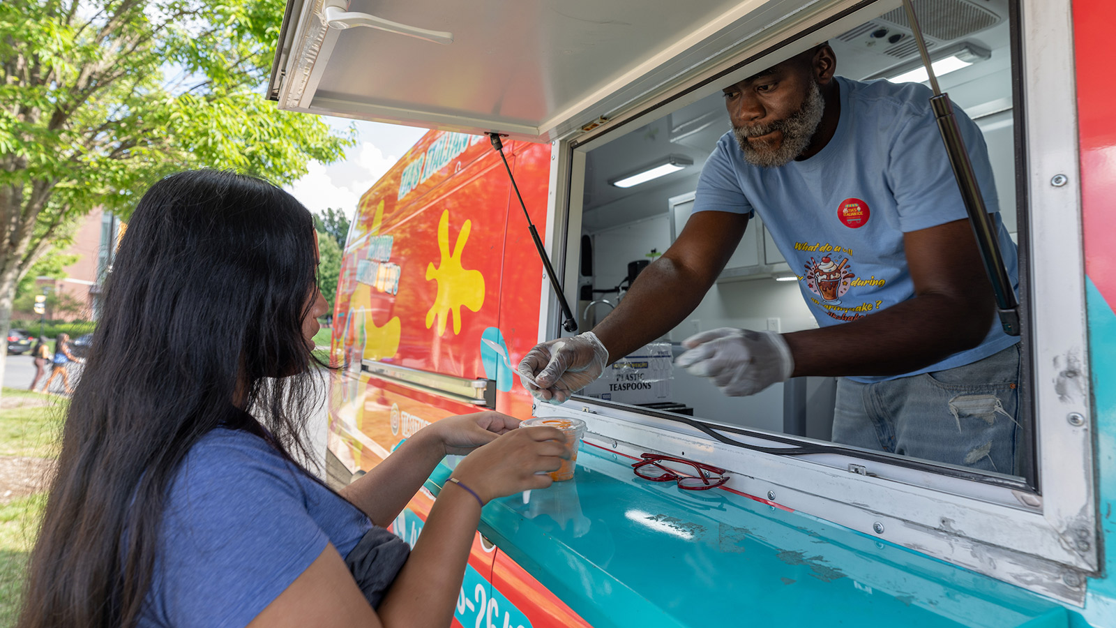 a student receiving a frozen treat from a food truck
