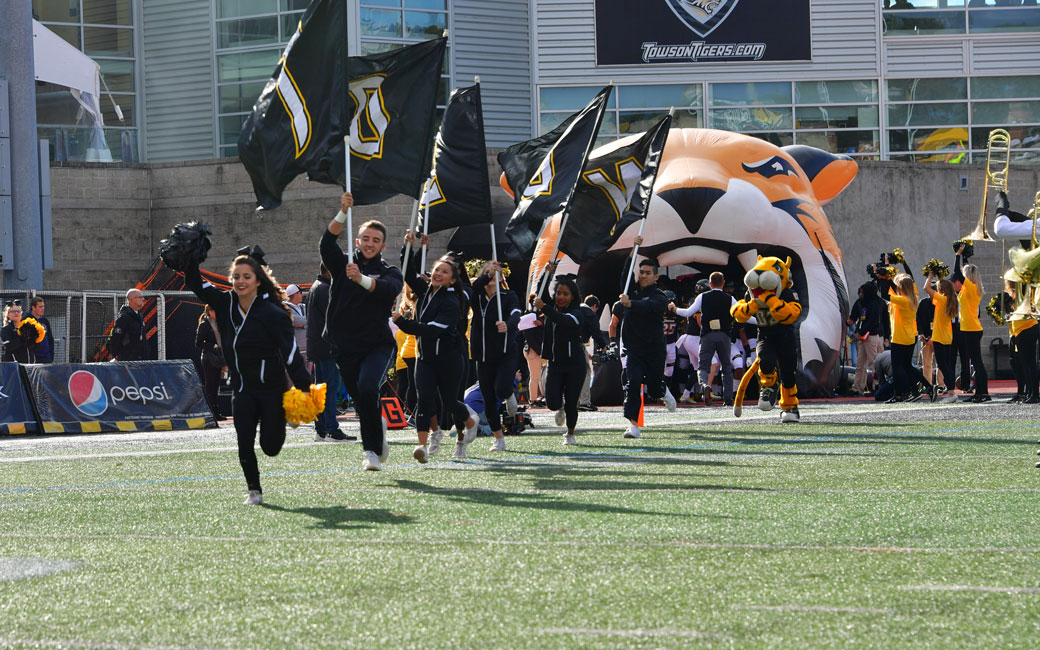 TU Cheerleaders lead the football team onto the field