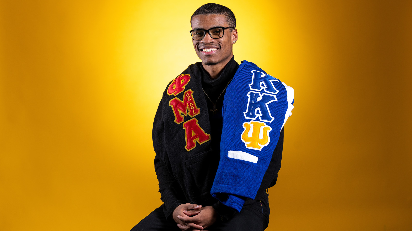 Bryce Lewis with sweaters from his greek organization