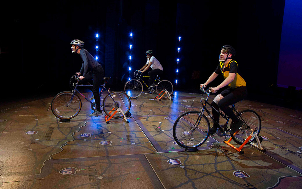Students on stationary bikes on stage