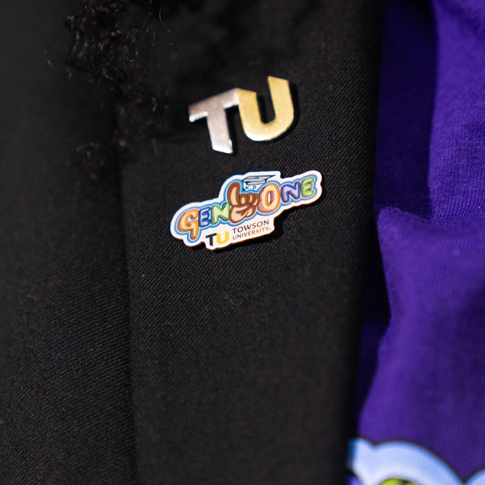 Close up of TU and Gen One pins on a lapel