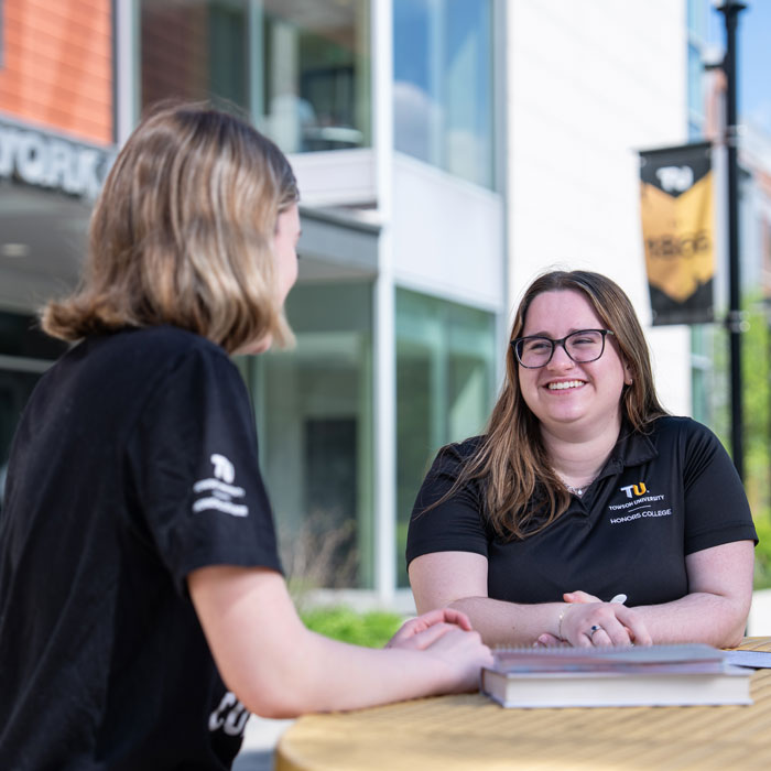 Leah Collidge sits with a student and discusses the Honors College