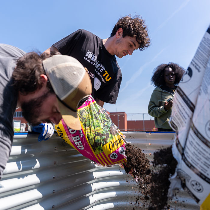 Fraternity members resoil a community garden