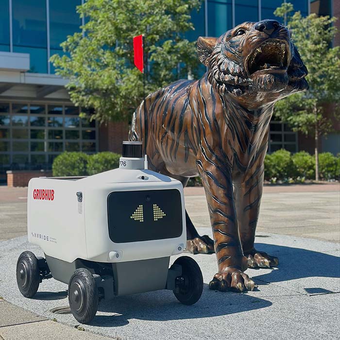 Grubhub food delivery robot next to a tiger statue