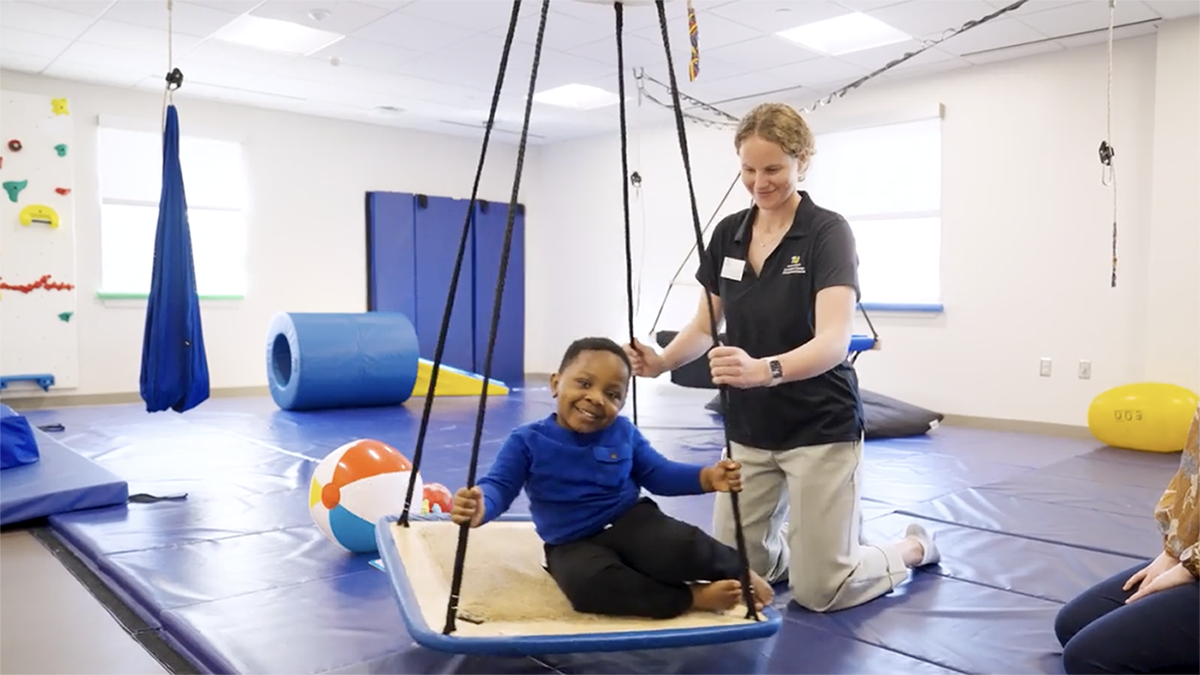 Kid on swing in occupational therapy space