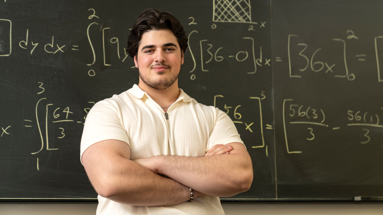 Jake Shaheen in front of a chalk board filled with linear equations