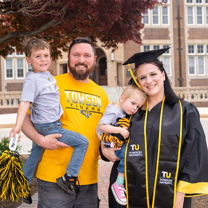 GIF of graduate in cap and gown with husband, two kids