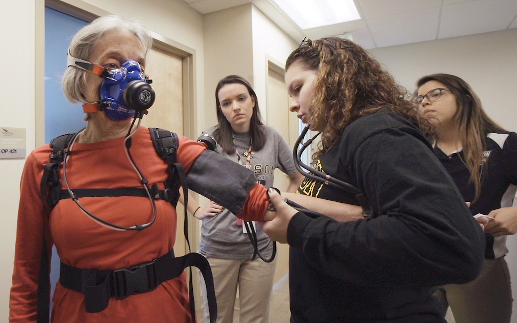 Three students with an older adult