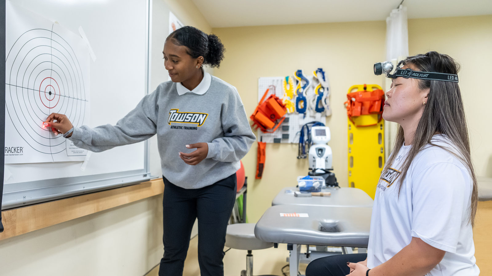Students simulate a visual concussion assessment in a lab-based clinic