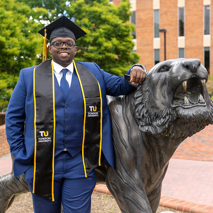 Student standing in front of Tiger statue