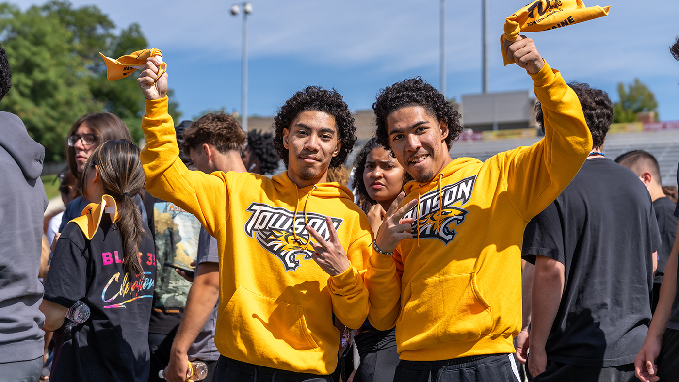 Two people in gold TU sweatshirts
