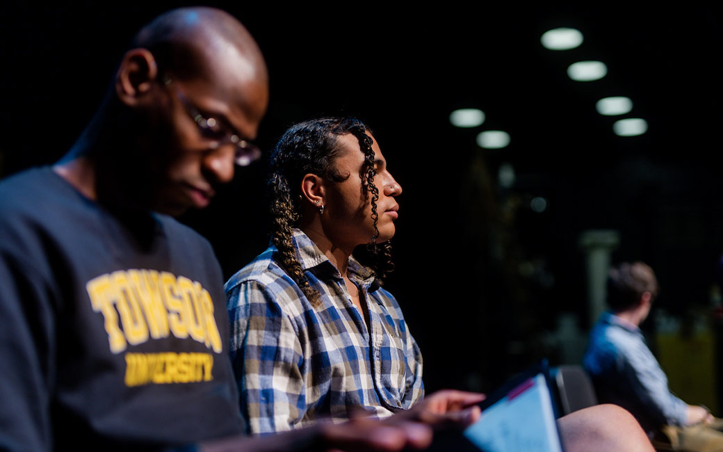 Students sit on stage