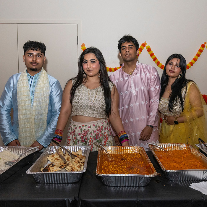 students giving out food at my big fat desi wedding