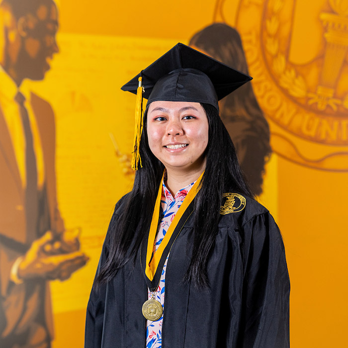 GIF of student in cap and gown with gold streamers falling